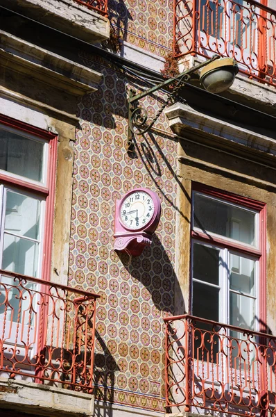 Uhr und die Laterne auf dem typischen alten Gebäude mit Keramikfliesen (Azulejos) im Zentrum von Lissabon (Portugal) dekoriert). — Stockfoto