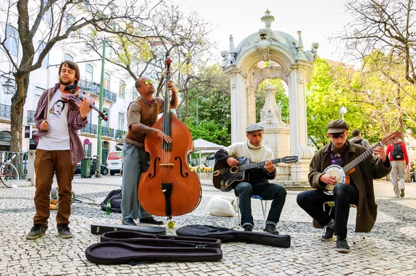 LISBOA, PORTUGAL - 22 de abril de 2015: Quatro músicos de rua não identificados tocam jazz e música folclórica na praça da cidade para turistas e cidadãos . — Fotografia de Stock