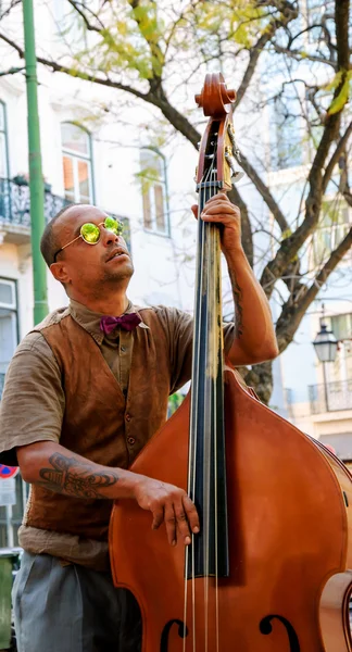 Lissabon, Portugal - 22. April 2015: Unbekannter Straßenmusiker mit Sonnenbrille tritt vor Touristen und Bürgern am Stadtplatz auf. — Stockfoto