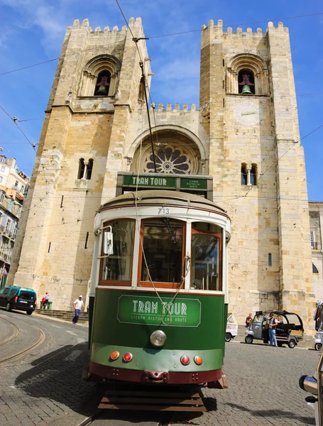 LISBOA, PORTUGAL - 23 DE ABRIL DE 2015: Antiguo tranvía circulando por la ruta histórica de Lisboa frente a la Catedral Patriarcal de Santa María la Mayor . — Foto de Stock