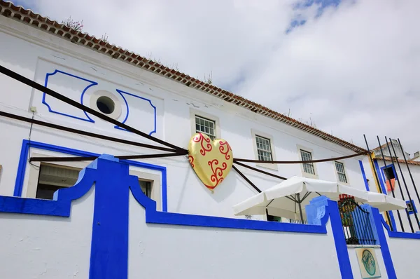 OBIDOS, PORTUGAL - 30 DE ABRIL DE 2015: Casa típica decorada con corazón de praliné en papel dorado durante el XIII Festival Internacional del Chocolate en la ciudad medieval de Obidos . — Foto de Stock