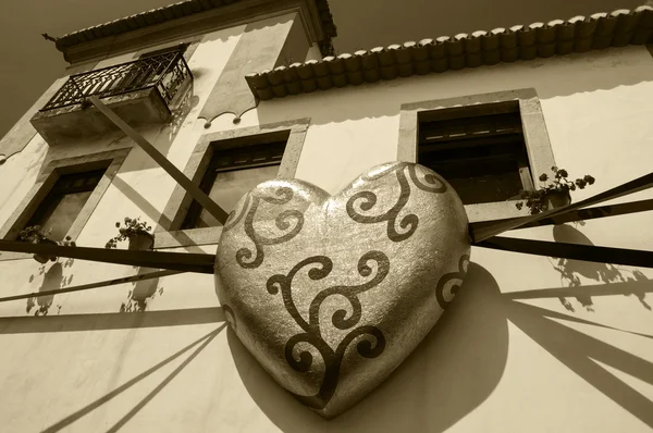 OBIDOS, PORTUGAL - 30 DE ABRIL DE 2015: Casa típica decorada con corazón de praliné en papel dorado durante el XIII Festival Internacional del Chocolate en la ciudad medieval de Obidos . —  Fotos de Stock