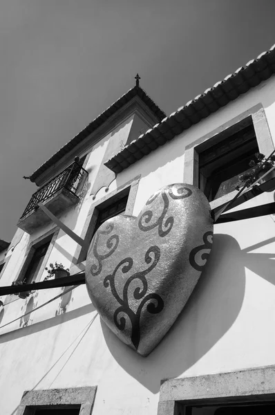 OBIDOS, PORTUGAL - APRIL 30, 2015: Typical house decorated with praline heart in golden wrap during the 13th  International Chocolate Festival in medieval town of Obidos. — Stock Photo, Image