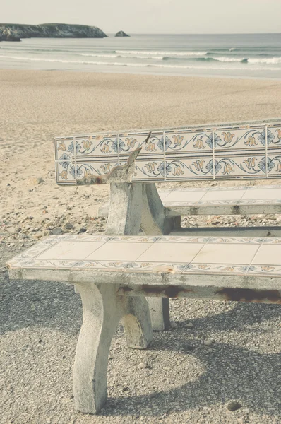 Tónovaný fotografie staré lavice zdobené keramické dlaždice (azulejos) a pláž v pozadí. Portugalsko. — Stock fotografie