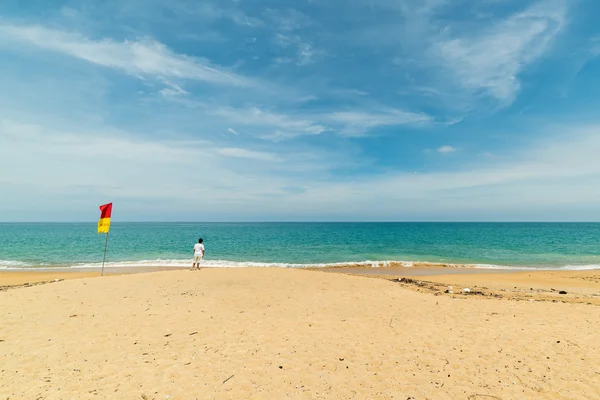 Ensam man stående på stranden — Stockfoto