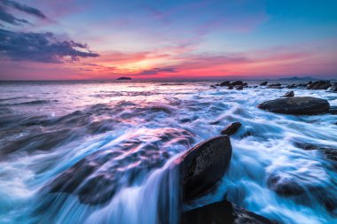 gün batımı sırasında plajda kayalar. Hareket Bulanıklığı, yumuşak odak