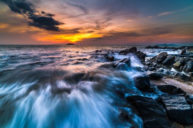 gün batımı sırasında plajda kayalar. Hareket Bulanıklığı, yumuşak odak