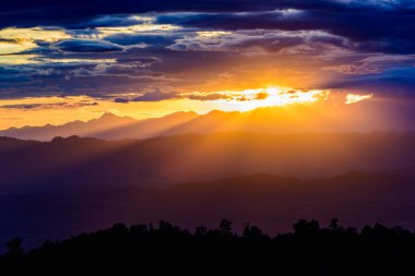 Dağların manzarasında muhteşem bir günbatımı. Dramatik gökyüzü.