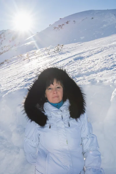 Medelålders brunett på en bakgrund av berg — Stockfoto