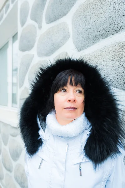 Middle-aged brunette on a background of mountains — Stock Photo, Image