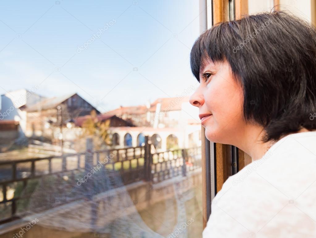 brunette woman looking out the window