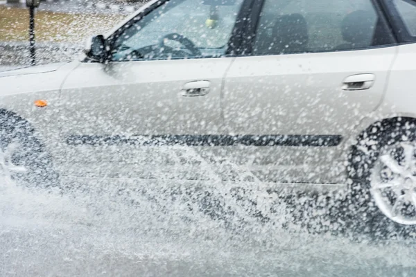 車の雨の水たまりが水を撒く — ストック写真