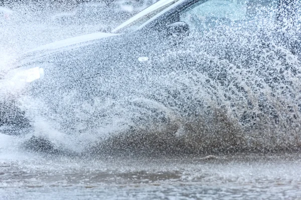 Автомобільна дощова калюжа бризкає воду — стокове фото