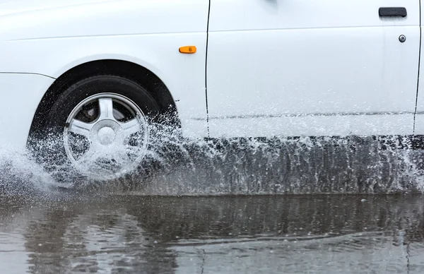 Автомобильная дождевая лужа с брызгами воды — стоковое фото