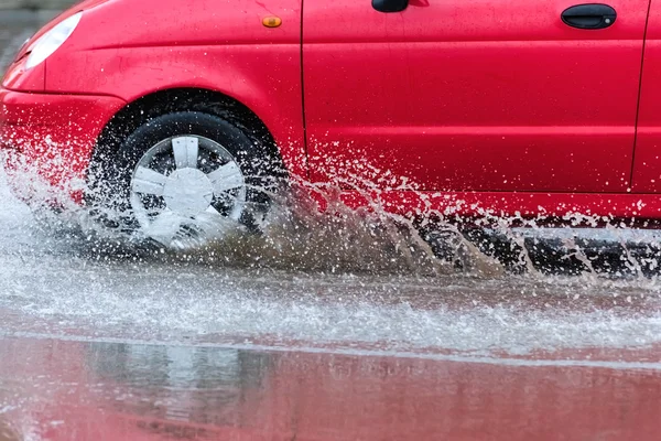 Автомобільна дощова калюжа бризкає воду — стокове фото