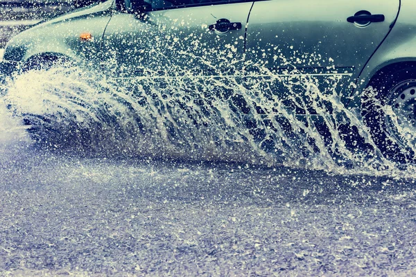 Coche lluvia charco salpicaduras de agua —  Fotos de Stock