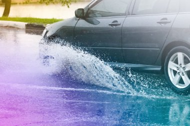 Araba yağmuru su sıçratıyor.