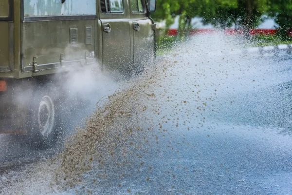 Автомобильная дождевая лужа с брызгами воды — стоковое фото