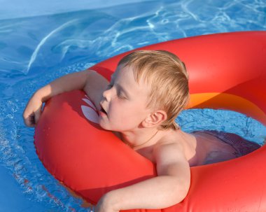 Suda şişirilebilir bir dairede küçük bir çocuk.