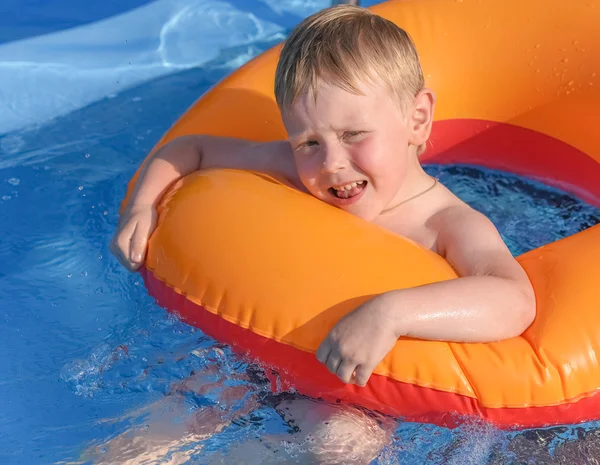 Kleine jongen op een opblaasbare cirkel in het water — Stockfoto