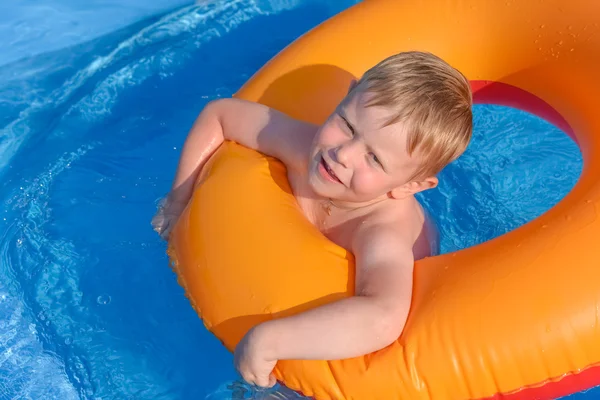 Kleine jongen op een opblaasbare cirkel in het water — Stockfoto