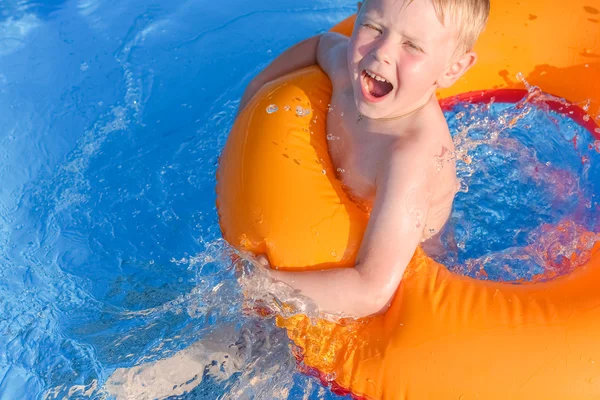 Malý chlapec na nafukovacím kruhu ve vodě — Stock fotografie