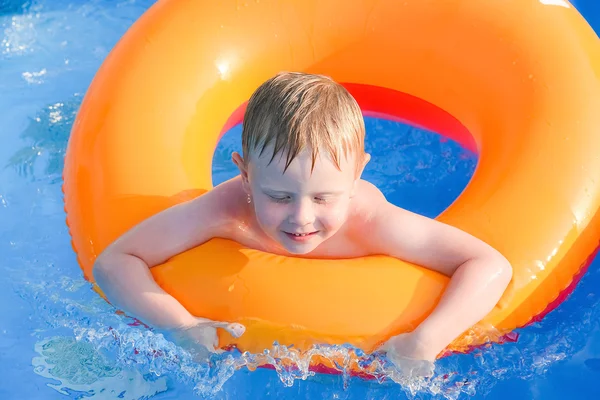 Kleine jongen op een opblaasbare cirkel in het water — Stockfoto
