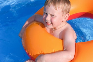 Suda şişirilebilir bir dairede küçük bir çocuk.