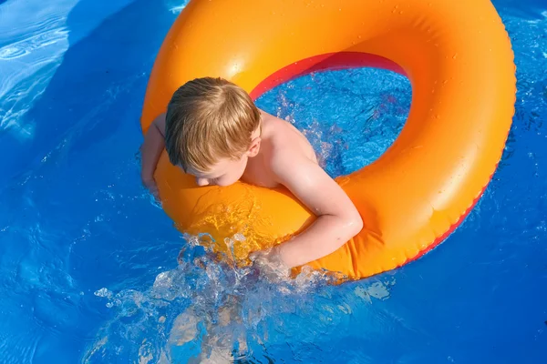 Kleine jongen op een opblaasbare cirkel in het water — Stockfoto