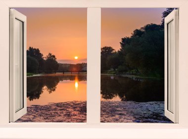 Sabahın erken saatlerinde pencereden gölet ve ağaçların üzerinden...