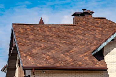 Evin çatısındaki baca mavi gökyüzüne karşı.