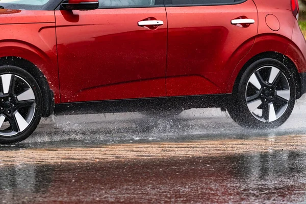 車輪からの水噴霧の動き車の雨の大きな水たまり — ストック写真