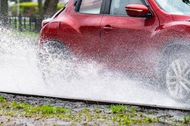 Hareket eden araba yağmuru Tekerleklerden fışkıran su birikintisi