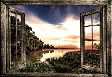 Yazın pencereden su ve ağaç manzarası.