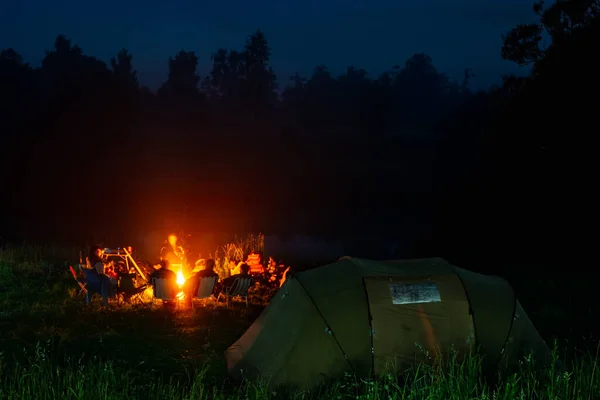 ハイキングで夜になるとキャンプファイヤーの周りに集まり — ストック写真