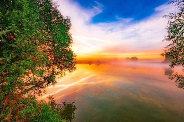池の朝の色鮮やかな穏やかな夜明け太陽の光が水面に反射し — ストック写真