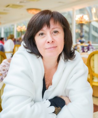 Orta yaşlı bir kadın kahverengi gözleri dairede oturan