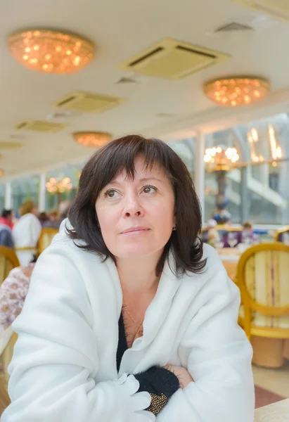 Middle-aged woman brown eyes is sitting in the apartment — Stock Photo, Image