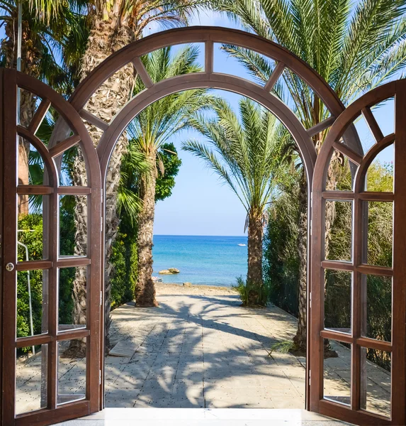 Arch door on the palm alley — Stock Photo, Image