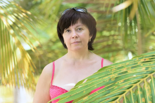 Mulher entre as palmas das mãos — Fotografia de Stock