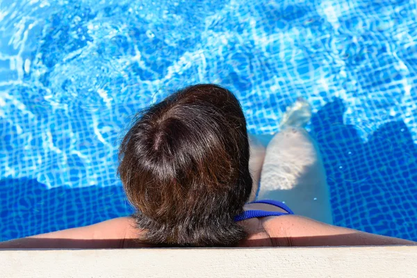 Donna è sdraiata vicino alla piscina — Foto Stock