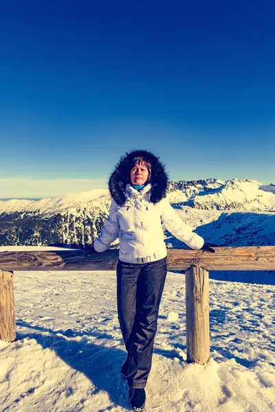 Middle-aged brunette on a background of mountains — Stock Photo, Image