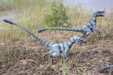 Dinozorlar Parkı. Doğanın arka planında bir dinozor. Lunaparktaki oyuncak dinozorlar..