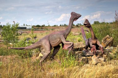Dinozorlar Parkı. Doğanın arka planında bir dinozor. Lunaparktaki oyuncak dinozorlar..