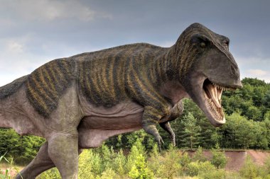 Dinozorlar Parkı. Doğanın arka planında bir dinozor. Lunaparktaki oyuncak dinozorlar..