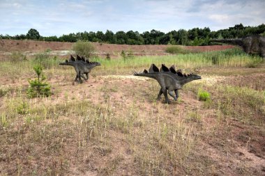 Dinozorlar Parkı. Doğanın arka planında bir dinozor. Lunaparktaki oyuncak dinozorlar..