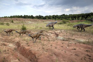 Dinozorlar Parkı. Doğanın arka planında bir dinozor. Lunaparktaki oyuncak dinozorlar..