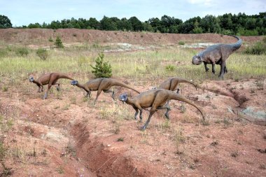 Dinozorlar Parkı. Doğanın arka planında bir dinozor. Lunaparktaki oyuncak dinozorlar..