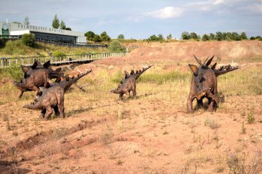 Dinozorlar Parkı. Doğanın arka planında bir dinozor. Lunaparktaki oyuncak dinozorlar..