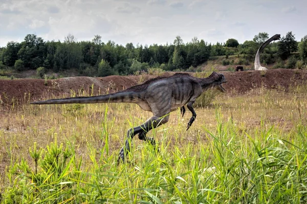Dinozorlar Parkı. Doğanın arka planında bir dinozor. Lunaparktaki oyuncak dinozorlar..